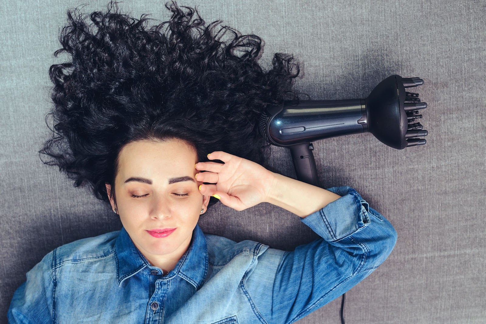 woman with curly hair and diffuser laying down
